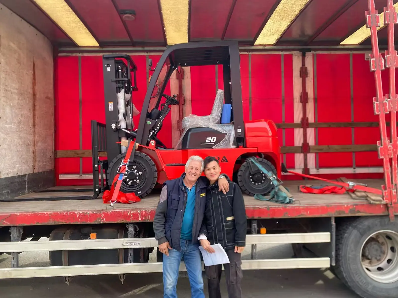 A TLERA forklift secured for delivery as the TLERA team meets with a customer